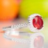 A captivating rich red halo design engagement ring