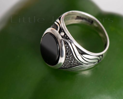 A sleek sterling silver men's ring that is uniquely detailed along the band.