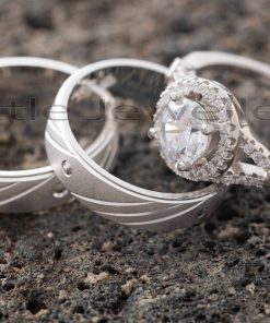 A finely detailed pair of silver wedding rings that are matched with a stunning engagement ring