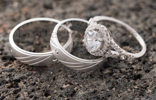 A finely detailed pair of silver wedding rings that are matched with a stunning engagement ring