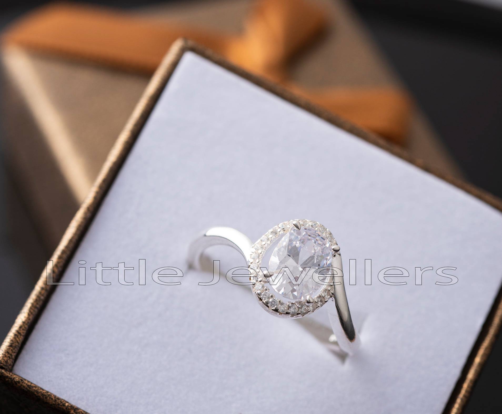 A striking halo setting sterling silver engagement ring, that is the perfect mix of charm and class