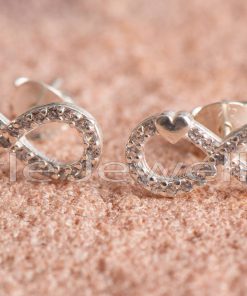 An enchanting pair of silver infinity earrings with a heart nestled among zirconia sparkles.