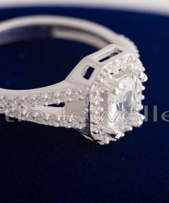 This classic split shank emerald cut halo engagement ring has a timeless finish and is set in pure silver.
