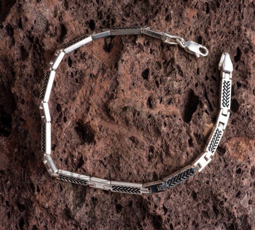 This men's bracelet is made of high-quality silver metal and features a black pattern design on the surface, giving it a very luxurious appearance.
