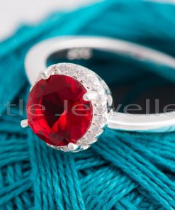 This gleaming Sterling Silver ring has an oval-cut red stone surrounded by a halo of pave cz stones. It will instill confidence, passion, and femininity in you.
