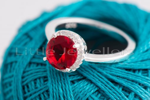 This gleaming Sterling Silver ring has an oval-cut red stone surrounded by a halo of pave cz stones. It will instill confidence, passion, and femininity in you.