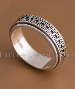 A men's ring featuring a center spinning band. The band features a patterned design in the middle and may spin freely.