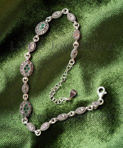 A vintage-style Marcasite bracelet made of pure sterling silver and set with green CZ stones.