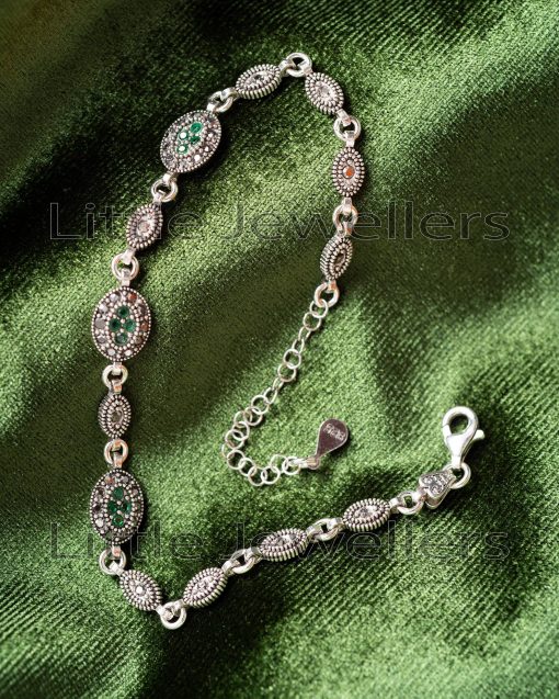 A vintage-style Marcasite bracelet made of pure sterling silver and set with green CZ stones.
