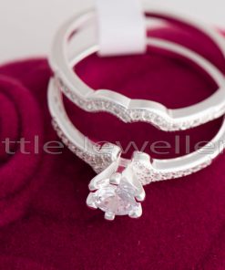 A contemporary double engagement ring with a cathedral setting and a thin band set with cubic zirconia stones.