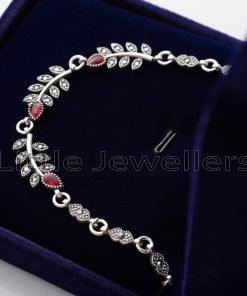 This striking silver bracelet exudes elegance and sophistication with its intricate leaf-like details and sparkling red stones. Each charm on the bracelet is carefully crafted to resemble a delicate leaf, creating a unique and eye-catching design.