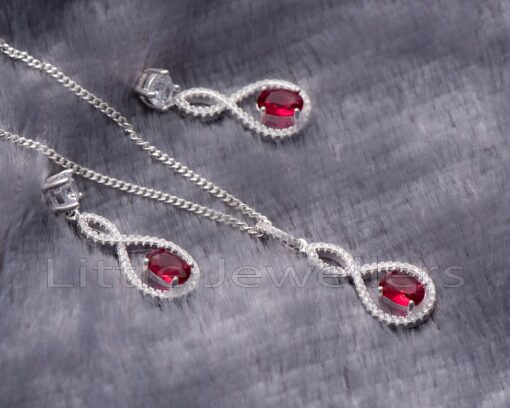 Make her smile with this beautiful sterling silver necklace and earrings set featuring a stunning red gem. The unique design catches the eye and will be sure to turn heads every time she wears it.