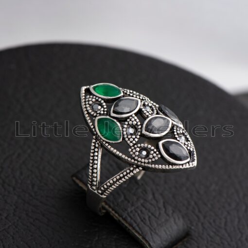 Looking for the perfect ring to make a statement at your next ruracio? Look no further! Our bold silver cocktail ring with stunning black & green gems is just what you need to add glamour and sparkle.