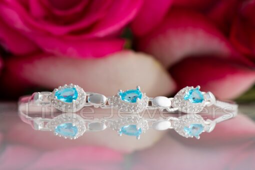 Beautify your look with this exquisite sterling silver bracelet, featuring a magnificent blue gem and hand-set zirconia stones. A perfect wrist jewellery choice for any occasion.